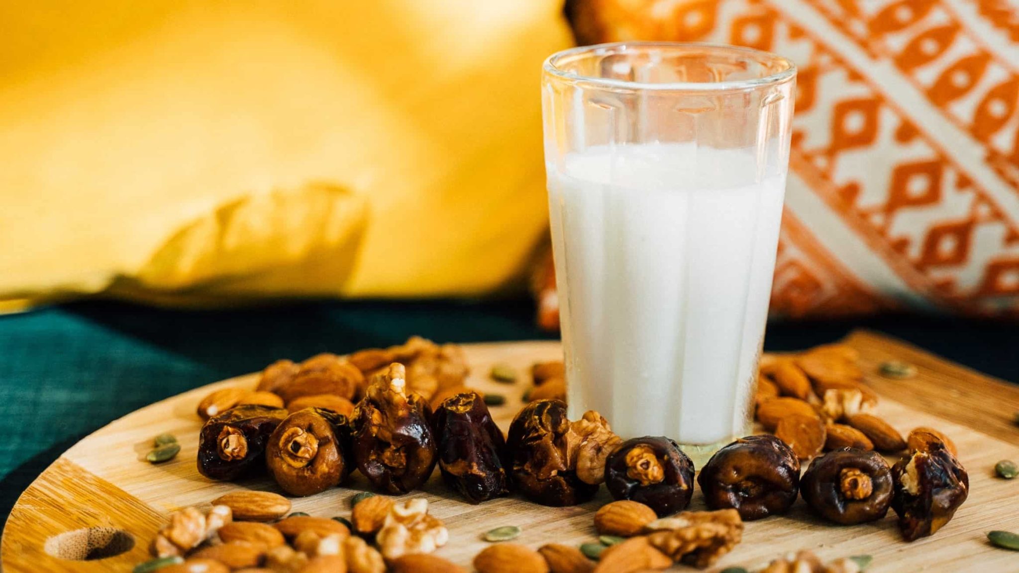 Dates, almonds, and glass of milk on platter